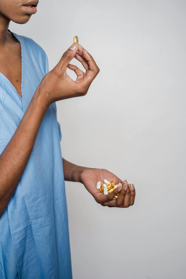 The image shows a patient holding supplement capsules in her hand.
