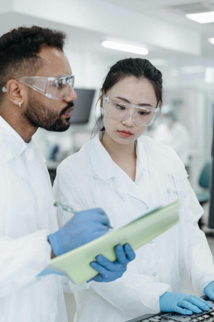 The image shows a couple of medical professionals in a white coat reviewing medical history in a laboratory setting.