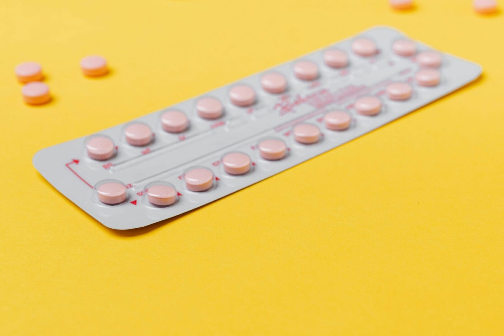 The image shows a blister strip surrounded by few pills in a yellow background.