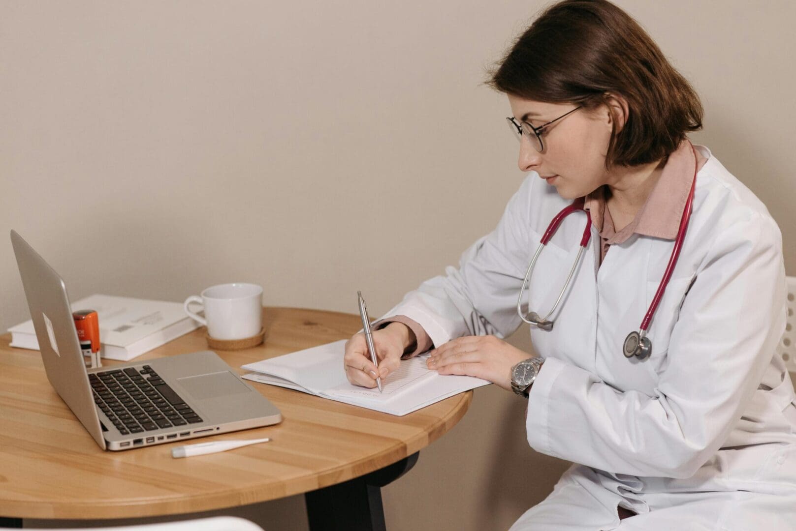 The image shows a Healthcare professional writing medical notes on paper.