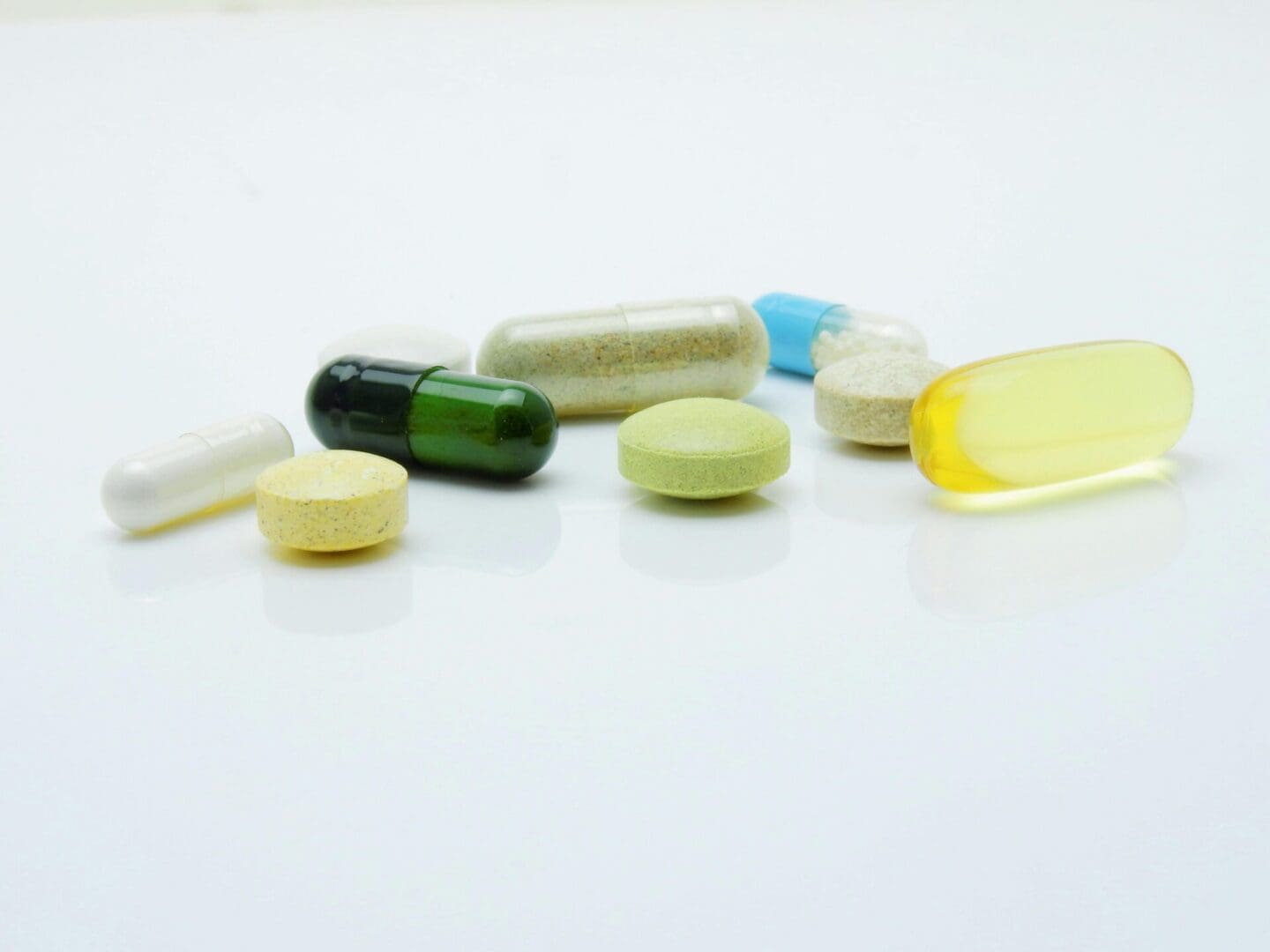 The image shows a variety of pharmaceutical pills and capsules.