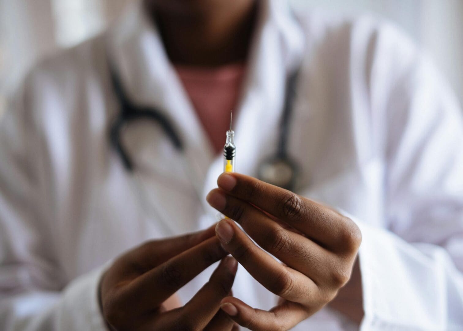 A Healthcare professional in a white coat holding a syringe as part of a medically supervised treatment plan.