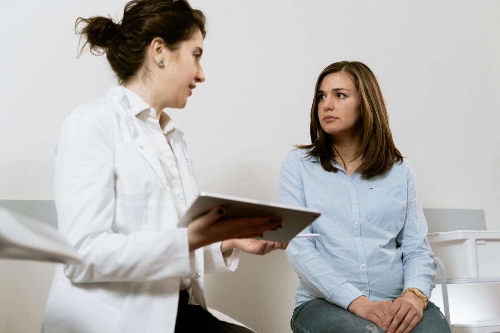 A Medical specialist is discussing a treatment plan with a patient in a clinical setting.