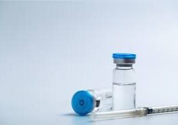 The image shows two vials and an injection placed on the table.