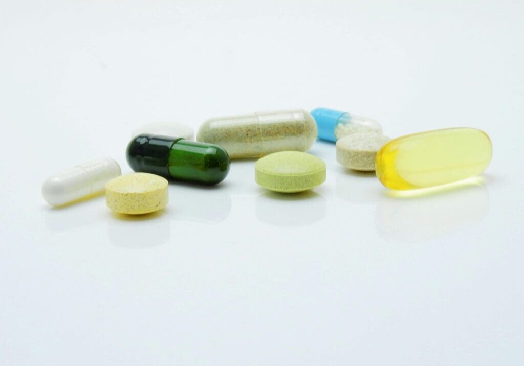 The image shows a variety of pharmaceutical pills and capsules.