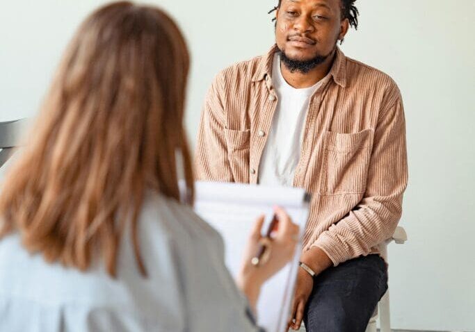 The image shows a healthcare provider is giving consultation to a patient in a clinic setting.
