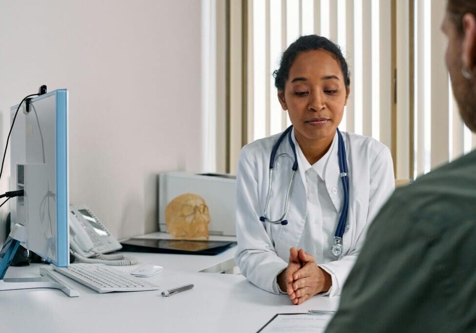 A Healthcare professional providing a medical consultation to a patient in a clinic.