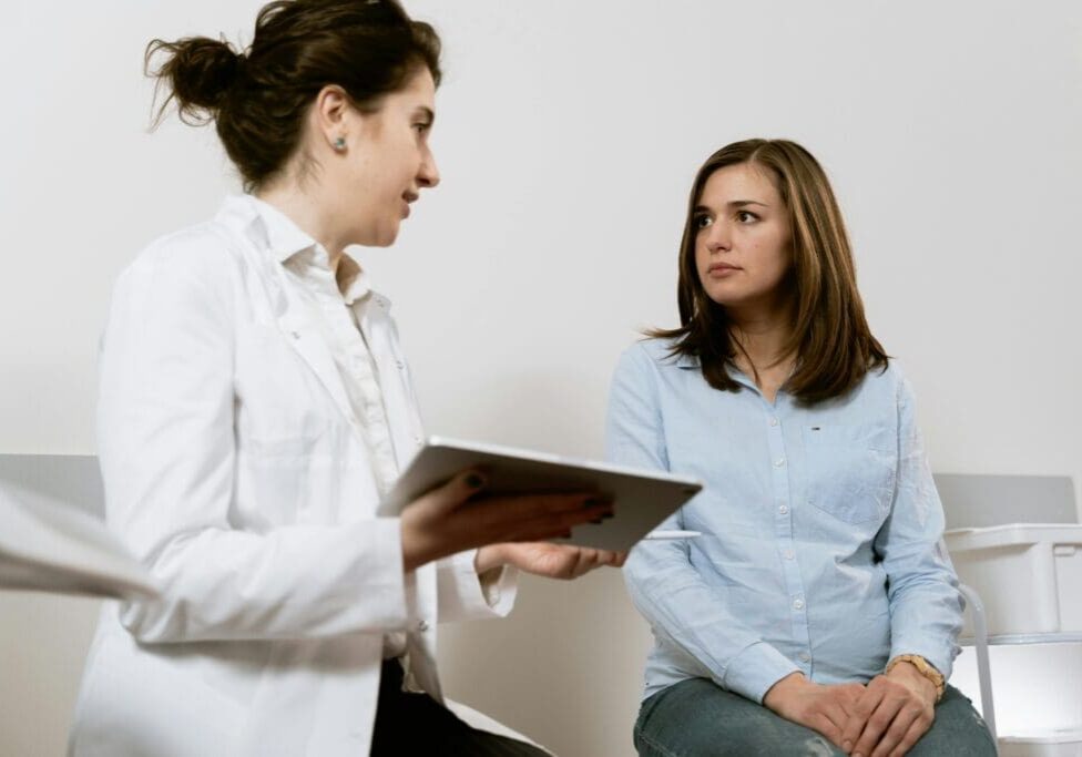 A Medical specialist is discussing a treatment plan with a patient in a clinical setting.
