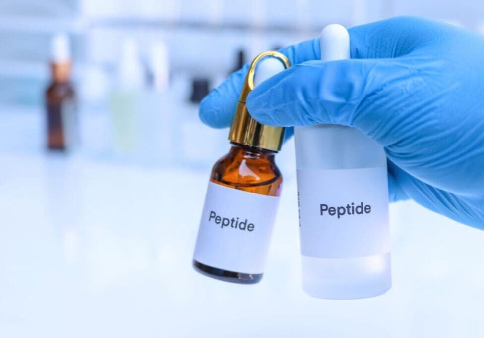 The image shows two vials labelled as peptides in a laboratory setting.